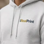 Close-up pe hanorac gri ash cu logo iRealPrint, accent pe lizibilitate și contrast