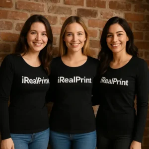 Grup de femei purtând bluze negre personalizate cu logo iRealPrint în fața unui perete din cărămidă, imagine de echipă și branding vizibil