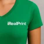 Detaliu personalizare logo pe tricou damă verde mediu cu anchior în V, transfer termic clar aplicat pe material din bumbac premium