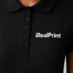 Detaliu logo aplicat prin transfer termic pe tricou polo damă negru, personalizare clară pentru branding premium