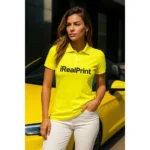 Femeie purtând tricou polo damă galben lămâie personalizat cu logo într-un cadru urban, imagine modernă pentru branding vizibil