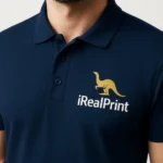 Detaliu personalizare logo iRealPrint pe tricou polo bărbați personalizat albastru nocturn, evidențiind textura materialului și claritatea transferului termic