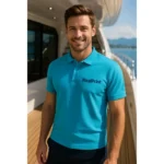 Bărbat purtând tricou polo personalizat turcoaz cu logo iRealPrint pe puntea unui yacht, stil business casual modern pentru promovare brand premium