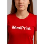 Detaliu logo iRealPrint aplicat prin transfer termic pe tricou damă personalizat roșu, evidențiind claritatea personalizării