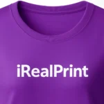 Detaliu personalizare logo iRealPrint aplicat prin transfer termic alb pe tricou damă mov, evidențiind claritatea printului