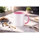 Cană personalizată cu interior roz pastel într-un decor de birou modern cu laptop și accesorii, sugerând utilizarea zilnică în mediul office