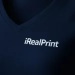 Detaliu personalizare logo pe tricou damă albastru navy cu anchior în V, transfer termic alb aplicat clar pe material bumbac premium