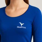 Detaliu personalizare logo iRealPrint aplicat prin transfer termic pe bluză damă albastru regal, material premium și contrast vizual puternic