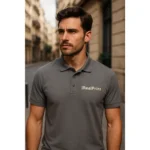 Bărbat purtând tricou polo gri metalic personalizat cu logo iRealPrint într-un decor urban modern, imagine lifestyle pentru branding premium