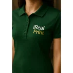 Detaliu personalizare logo iRealPrint aplicat prin transfer termic pe tricou polo damă personalizat verde dark, evidențiind claritatea printului și textura materialului