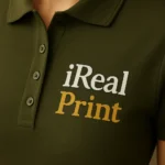 Detaliu logo iRealPrint aplicat prin transfer termic pe tricou polo damă verde militar cu contrast puternic și claritate ridicată