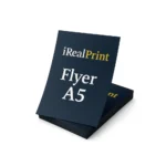 Flyer A5 personalizat prezentat pe o stivă de materiale promoționale pentru evidențierea calității tiparului profesional.