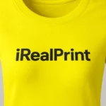 Detaliu personalizare logo iRealPrint aplicat prin transfer termic pe tricou damă personalizat galben lămâie, imprimare clară cu contrast puternic