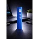 Baterie externă personalizată albastră utilizată pe birou lângă laptop, power bank promoțional pentru profesioniști și mediul business