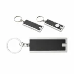 Set breloc cu lumină LED negru prezentat din față și spate, evidențiind designul metalic și funcționalitatea practică pentru branding B2B