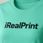 Detaliu personalizare logo iRealPrint negru pe tricou damă verde mentă, contrast puternic și imprimare precisă