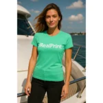 Model feminin purtând tricou damă personalizat verde mentă pe puntea unui yacht, exemplu de outfit casual premium