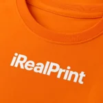 Detaliu logo iRealPrint aplicat prin transfer termic alb pe tricou damă personalizat portocaliu, evidențiind textura materialului și claritatea personalizării