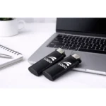 Brichete tip BIC personalizate negre cu logo prezentate lângă laptop pe birou modern, produse promoționale utilizate în campanii corporate și materiale de branding.