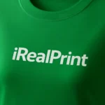 Detaliu logo iRealPrint alb aplicat prin transfer termic pe tricou damă personalizat verde mediu, imprimare clară pe material din bumbac