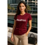 Detaliu personalizare logo iRealPrint aplicat prin transfer termic pe tricou damă personalizat garnet, contrast clar pe fundal roșu intens