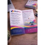 Pliant A5 personalizat deschis pe birou lângă laptop, utilizat pentru prezentarea serviciilor și ofertelor într-un mod clar și profesionist