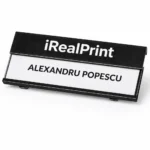 Detaliu ecuson aluminiu negru cu personalizare precisa, contrast ridicat intre text si fundal pentru lizibilitate maxima